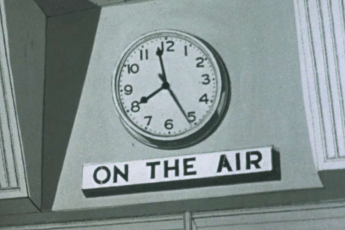 a clock with a sign below “On the air”